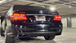 2010 Mercedes-Benz E63 AMG parked, featuring sleek design, vibrant taillights, and polished finish.