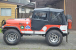 1974 one-owner Jeep CJ5 with custom lift, off-road tires, and bright orange exterior