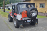 1974 Jeep CJ5 with off-road features and custom modifications parked on a residential street