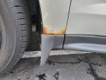 Close-up of rust starting on the side of a 2013 Chevrolet Equinox LT AWD near the tire.