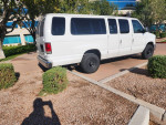 2012 Ford E-350 XLT van parked, spacious 15-passenger seating, clean interior, no mechanical issues.