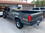 1999 GMC SLE K3500 4x4 in Storm Gray Metallic with low mileage, showing rear view and pickup truck features.