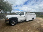 2001 Chevrolet Silverado 1500 with service body, towing receiver, and ladder rack in rural setting.