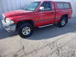 1995 Dodge Ram 1500 SLT V8 in red with off-road tires parked on pavement in Albuquerque, NM