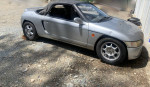 1991 Honda Beat Convertible, silver car with broken timing belt and damaged engine block, parked on gravel.