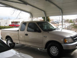 1999 Ford F150 XL in garage, low mileage, well-maintained with new tires and fiberglass bed cover