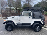 1999 Jeep Wrangler Sahara 4WD in excellent condition with off-road tires and roof rack.