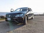 2018 Volkswagen Tiguan parked by the water, showcasing its sleek design and alloy wheels.