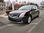 2010 Nissan Sentra in black, parked in a lot, features automatic AC and Bluetooth, in excellent condition.