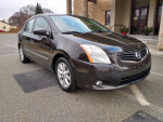 2010 Nissan Sentra SL parked, featuring automatic AC, Bluetooth, and alloy wheels, excellent condition with low mileage.