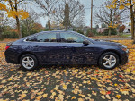 2018 Chevrolet Malibu LT FWD in dark blue parked in a leaf-covered lot, showcasing its clean design.