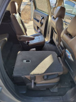 Interior view of a 2015 GMC Acadia showing leather seating and foldable rear seats.