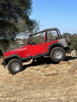 1994 Jeep Wrangler offroading on rocky terrain with lifted suspension and all-terrain tires.