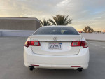 2010 Acura TSX in White Pearl, excellent condition, parked in a spacious lot during sunset.