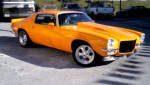 Classic 1970 Chevrolet Camaro Z-28 in bright orange with chrome wheels.