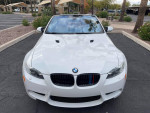 Front view of a white 2012 BMW M3 Convertible parked in a lot, showcasing its sleek design.