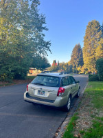 2008 Subaru Outback 2.5 XT Limited AWD parked on a suburban street, showcasing its gold paint and clean exterior.