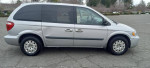 2006 Chrysler Town and Country minivan in silver color parked on asphalt, showing small scratches and dents.