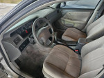 Interior view of a 2000 Toyota Camry LE with gray upholstery and dashboard, showcasing low mileage and features.