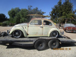 Side view of a classic 1963 VW Bug with a patina paint job on a trailer.