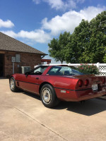1987 Chevrolet Corvette in original condition parked on driveway with trees and blue sky