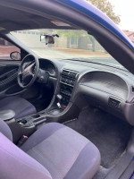 Interior view of a 2004 Ford Mustang with clean upholstery and dashboard, ideal for daily driving.