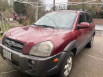 2005 Hyundai Tucson SUV in maroon color, featuring a V6 engine, automatic transmission and roof rack.