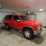 1999 Chevrolet Tahoe SUV in great condition, red color, parked in garage with detailed maintenance records