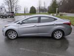 2015 Hyundai Elantra parked with winter tires, showcasing a sleek silver design and excellent condition.