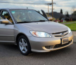 2004 Honda Civic EX sedan, silver color, parked with doors ajar, low mileage at 84,000, ready for sale.