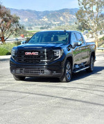 2022 GMC Sierra X31 SLT, a black diesel 4X4 truck, parked outdoors with scenic background.