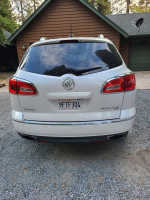 Rear view of a 2016 Buick Enclave in excellent condition, showcasing white frost exterior and Choccochino interior.