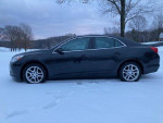 2013 Chevrolet Malibu LT in black, parked in snowy landscape, ideal for commuters and families.