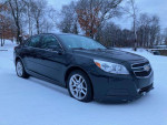 2013 Chevrolet Malibu LT FWD parked in snow, featuring touchscreen and navigation, ideal for commuting.