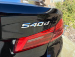 Rear view of a black 2018 BMW 540d xDrive showcasing the model badge and sleek design.