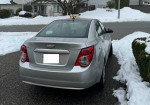 2012 Chevrolet Sonic parked in a snowy driveway, showcasing its excellent condition and sleek design.