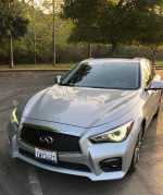 2015 Infiniti Q50 Sport in Liquid Platinum color parked outdoors with trees in the background