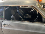 Interior view of a 1970 Ford Mustang Coupe showing black leather seats and dashboard gauges.
