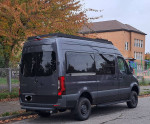 2023 Mercedes-Benz Sprinter van with AWD, designed for 4 passengers, parked in an autumn scene.