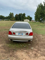 2002 Lexus ES 300 parked on grass, showing rear view with faded paint and damaged bumper