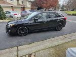 2016 Subaru Impreza Hatchback in black with low mileage, located in a residential area.