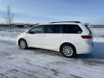 2015 Toyota Sienna LE 7-Passenger AWD parked on a snowy road with a clear sky.