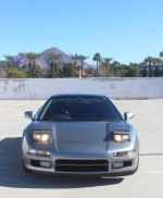 Front view of a silver 1991 Acura NSX in a desert setting, showcasing its sleek design.