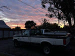 1990 Ford F-250 XLT Lariat parked outdoors during sunset, highlighting its classic design and condition.