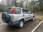 2001 Honda CRV with low mileage, clean title, and all-wheel-drive, parked in a wooded area.