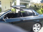 Interior of a black 2009 BMW 328i convertible with an automated hard top open, showcasing a well-maintained design.