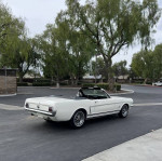 1965 Ford Mustang Convertible in excellent condition, parked with trees in background.