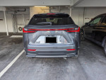 2023 Lexus NX 350h AWD parked, showcasing its sleek rear design in a parking area.