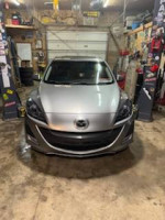 2011 Mazda 3 s Sport Hatchback in a garage with custom headlights and new wheels.