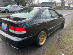 1996 Honda Civic with manual transmission, gold rims, and clean title, parked on the street.